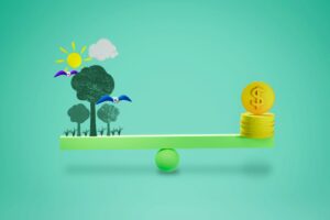 Coins,On,Scales,With,The,Environment,,Balancing,Money,And,Nature, A balance scale with trees, birds, the sun, and clouds on one side, and stack of coins with a dollar symbol on the other side, representing environmental and economic balance.
