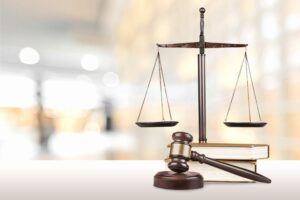 Law. A gavel and scales of justice on top of stacked books, symbolizing law and justice.