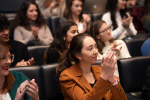 Turner Speaker Series Gregg Renfrew 3 Audience clapping in auditorium with black leather seats