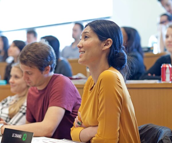 Wharton MBA Students sitting in a tiered Huntsman Hall classroom