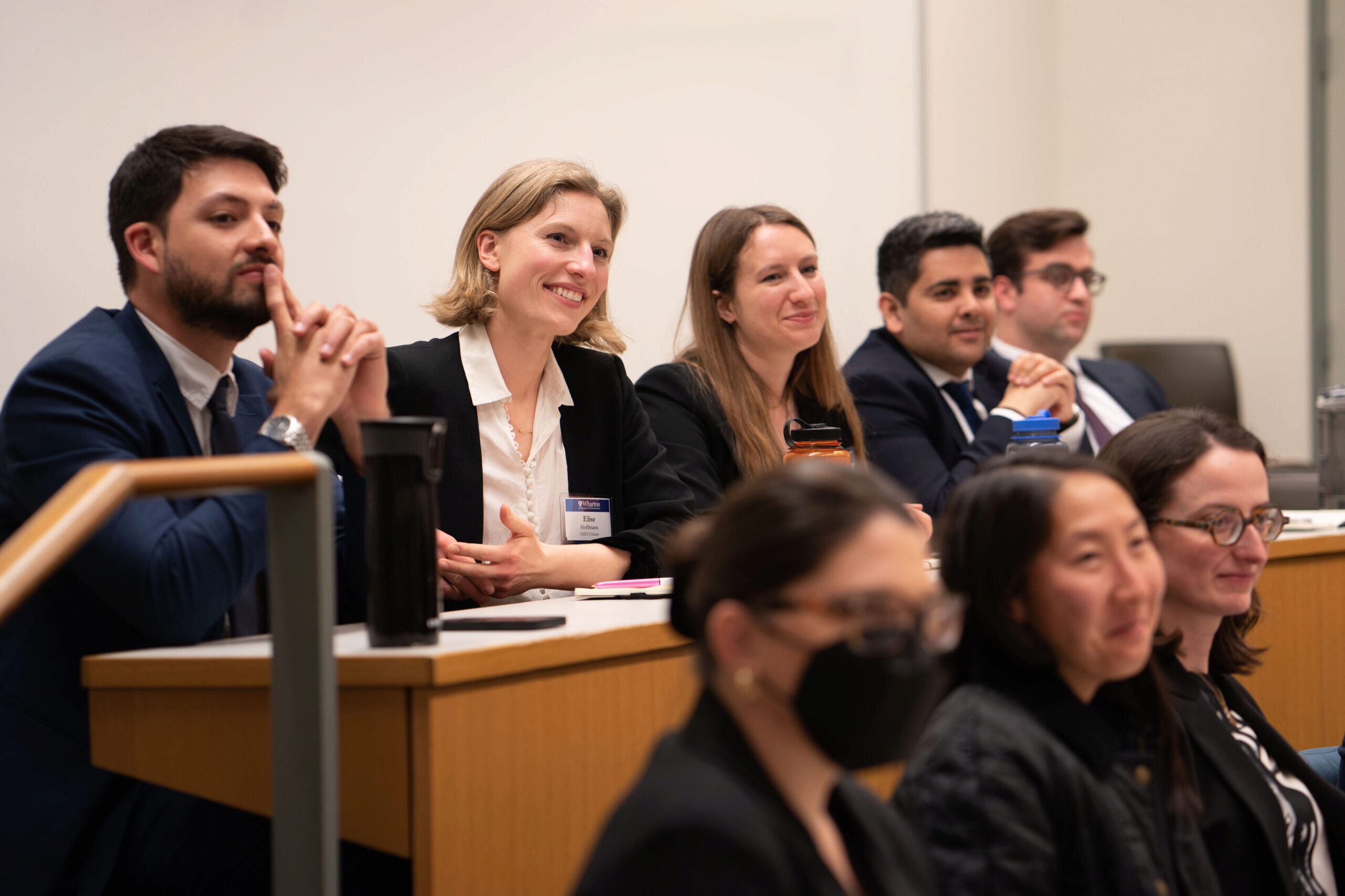 Students sitting in a classroom smile while watching their fellow participants present during the TMIINT Semi Finals