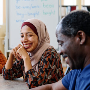 Stock Image English Lesson 3 Stock image of immigrants sitting at a table smiling during an English lesson