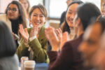 Students at a table clapping.