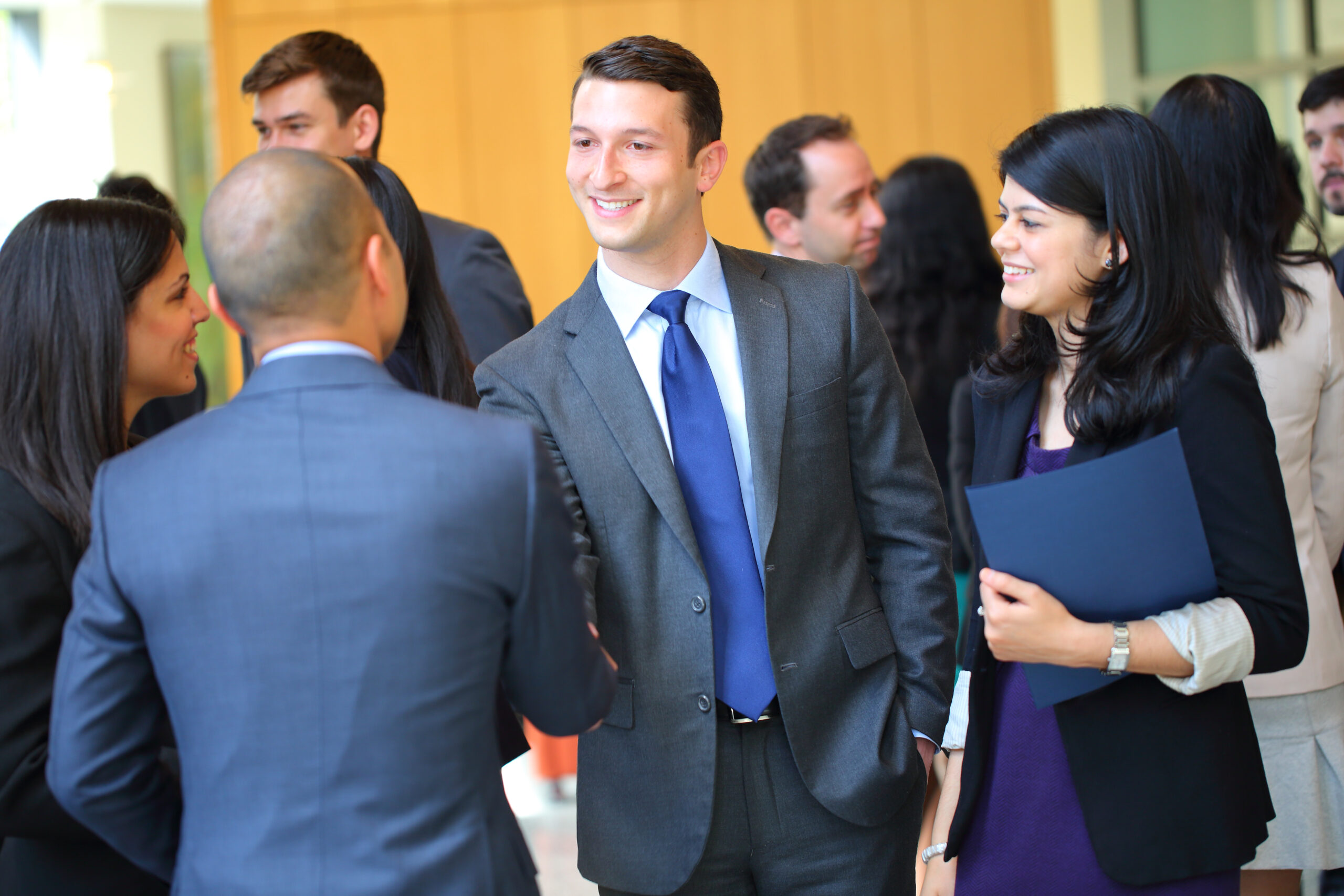 MBACM StudentsandRecruiters IMG 3198 Wharton students in business professional attire shake hands with a recruiter at a career fair.