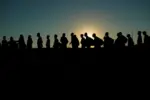 Migrants who crossed the Rio Grande and entered the U.S. from Mexico are lined up for processing by U.S. Customs and Border Protection, Sept. 23, 2023, in Eagle Pass, Texas.