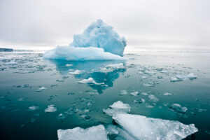 A,Wide,Low,Angle,View,Of,Melting,Sea,Ice,Floes Melting ice with a few large chunks from a low angle, receding into horizon.
