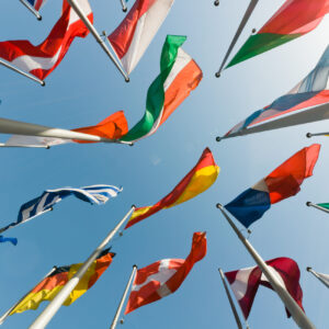 Flags Photo looking up at a blue sky with about 20 nation's flags.